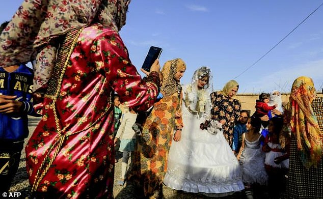 Ο πρώτος γάμος στην ελεύθερη Ράκα με νυφικό, κραγιόν και κινητά (Photos)