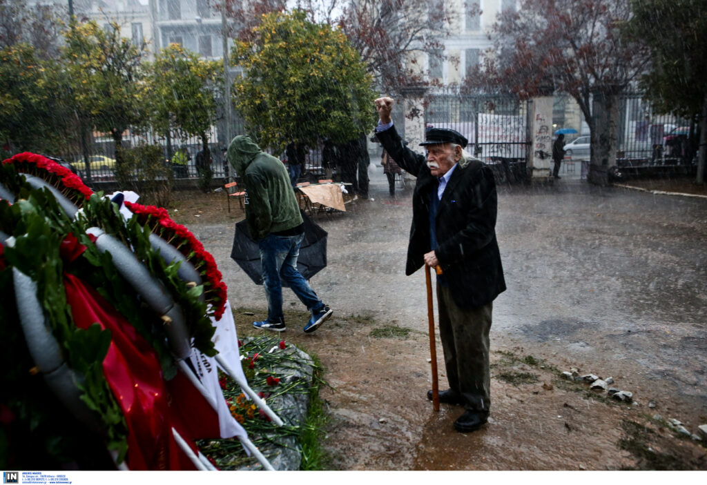 Ο Μανώλης Γλέζος με υψωμένη γροθιά στη βροχή αποτίει φόρο τιμής στους νεκρούς του Πολυτεχνείου (Photo)