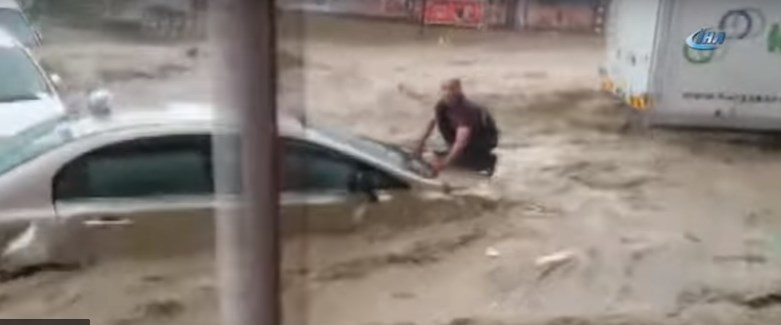 Άνδρας σκαρφαλώνει στο καπό αυτοκινήτου για να σωθεί σε πλημμυρισμένο δρόμο! (Video)